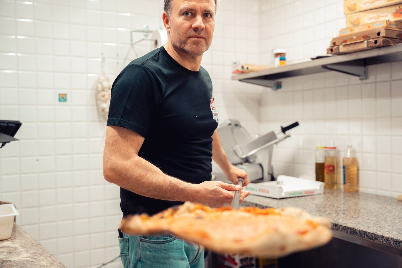 Il pizzaiolo della Pizzeria Barbarossa al lavoro dietro il bancone
